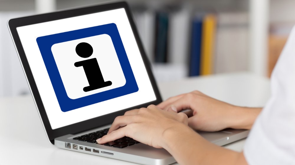 kvinnehender på laptop med infoskilt på skjermen